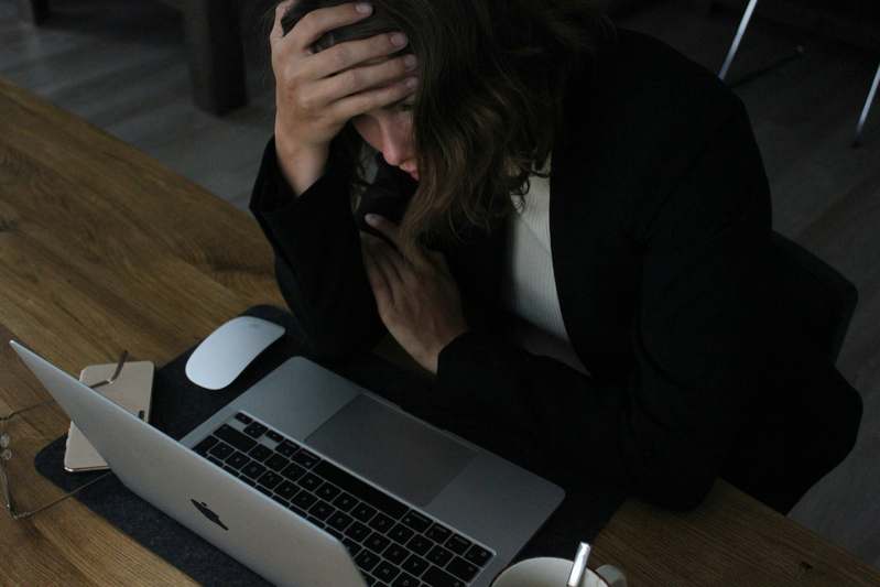 Person meditating peacefully with a smartphone showing a stress management app on screen